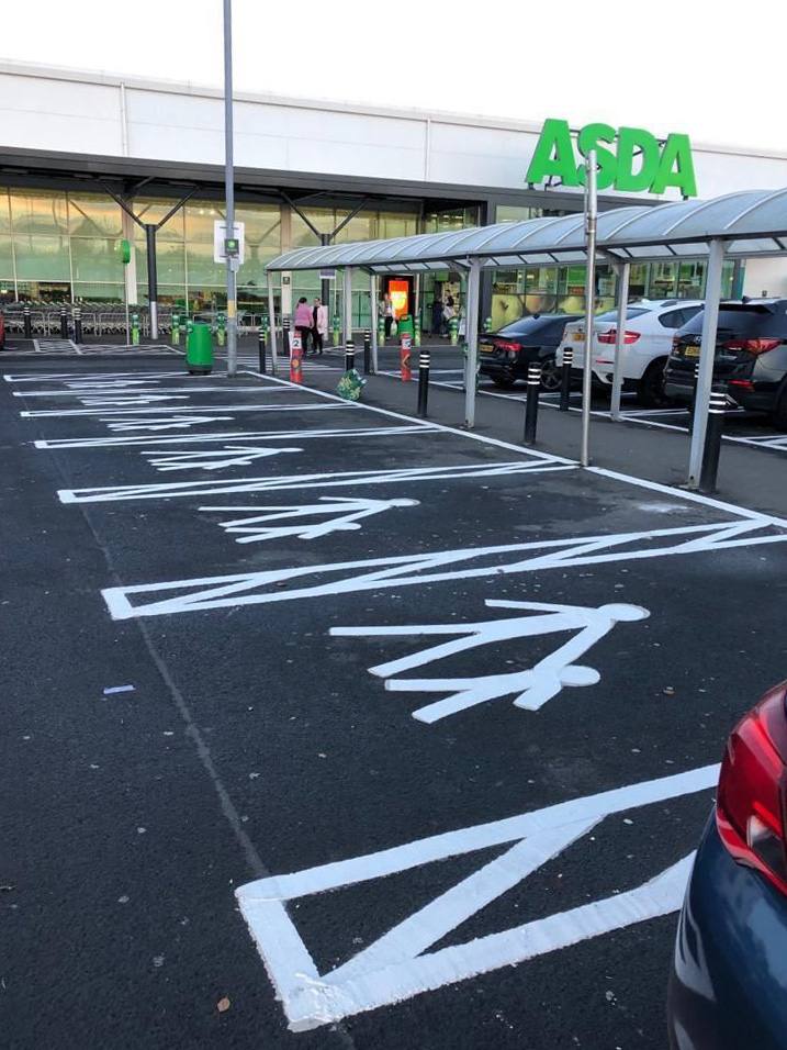 Newly laid car park markings including hatching and disabled bay symbols outside the store.