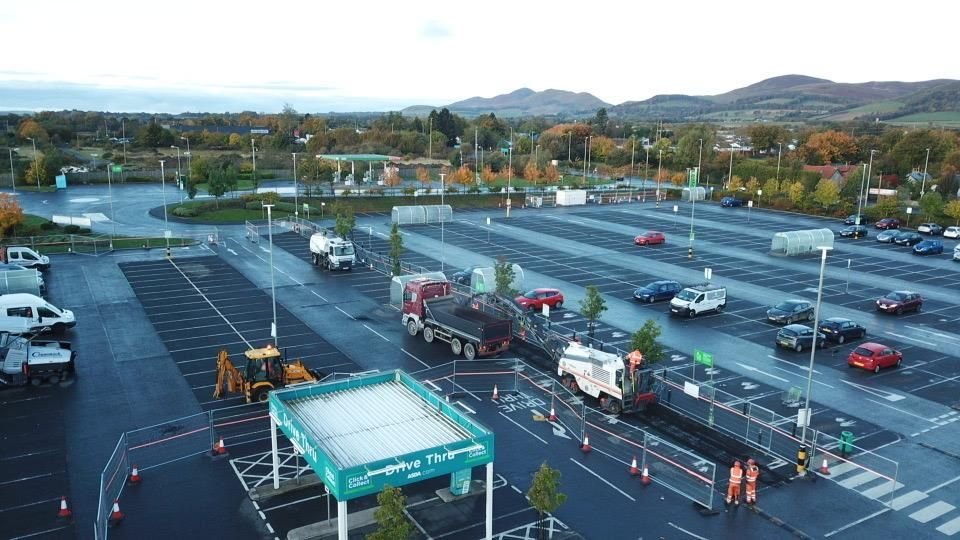 Wide aerial of the full car park with the works coned off and traffic still running.