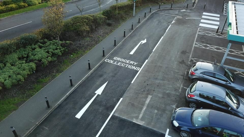 Newly marked grocery collection lane with directional arrows on fresh asphalt.