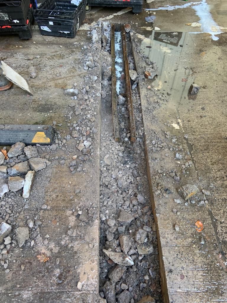 Broken out trench beside the loading bay with rubble ready to be cleared.
