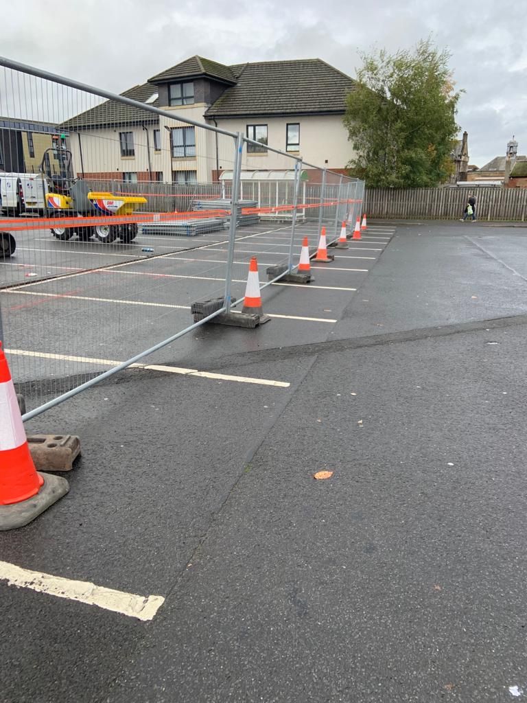 Coned off strip of car park with the reinstated drainage line running through the parking bays.